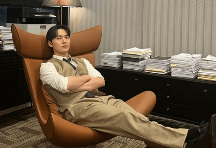 韓国ドラマ「太陽を抱く月」に出演している俳優イ・ミノ（現在イ・テリ）の画像
ソファーに深く腰掛けていて、ベージュのスーツを着用している